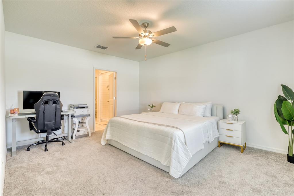 111 Rain Lily Ave Spring Hill Spring Hill, FL 34609 - Photo 39 of 60 a bedroom with a bed a window and a potted plant on the dresser