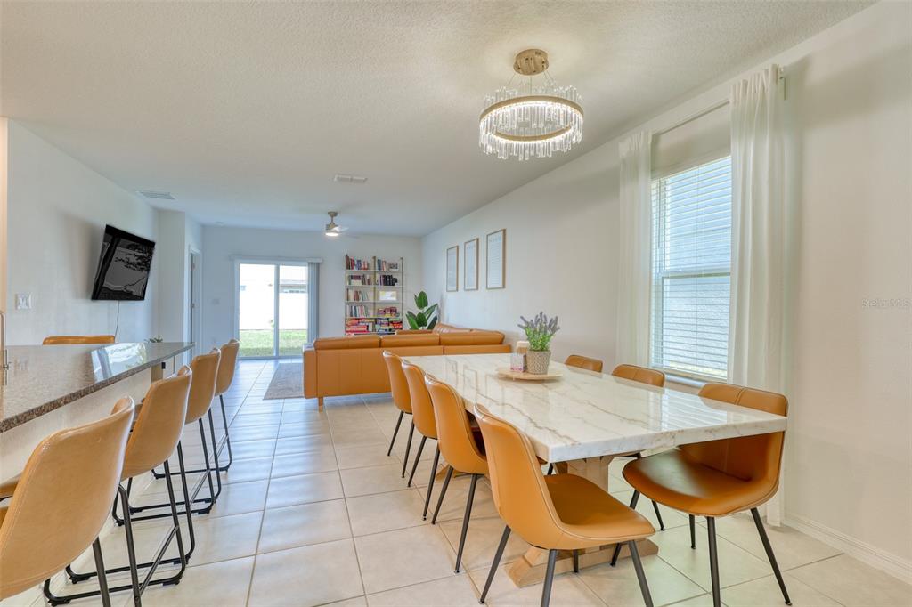 111 Rain Lily Ave Spring Hill Spring Hill, FL 34609 - Photo 5 of 60 a view of a dining room and livingroom with furniture wooden floor and a rug