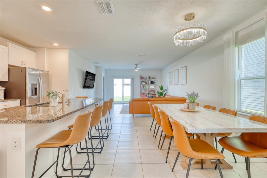 111 Rain Lily Ave Spring Hill Spring Hill, FL 34609 - Photo 8 of 60 a dining room with stainless steel appliances granite countertop a table chairs and a refrigerator