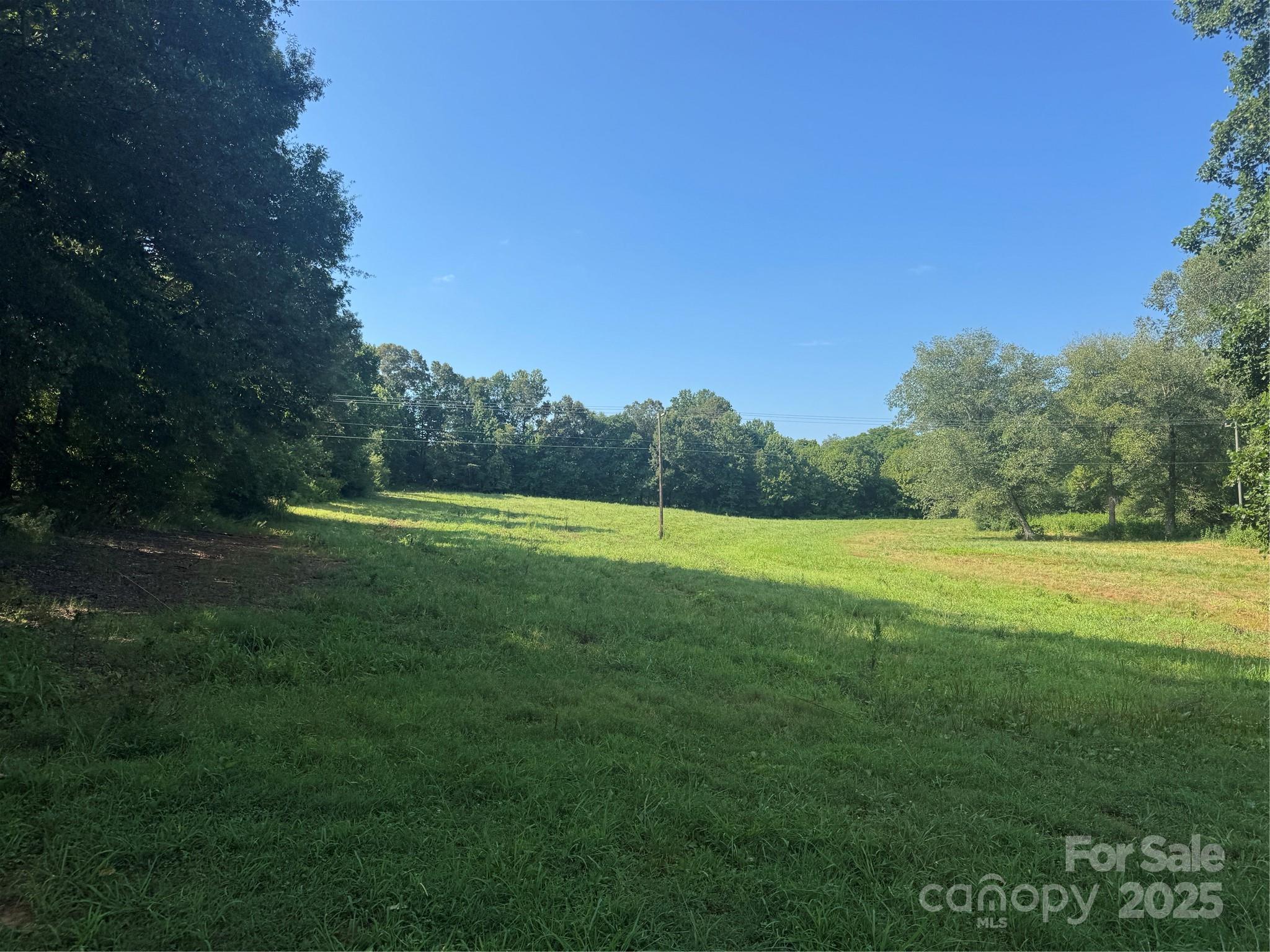 a view of a green field with wooden fence