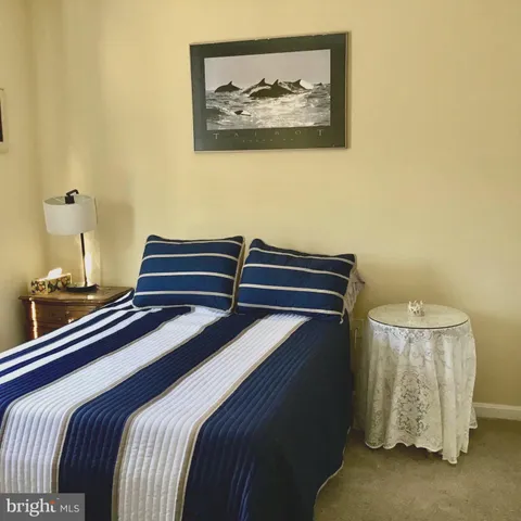 a bedroom with a bed and a lamp on the dresser