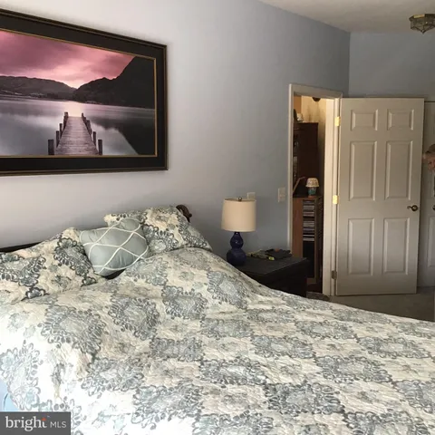 a bedroom with a bed and painting on the wall