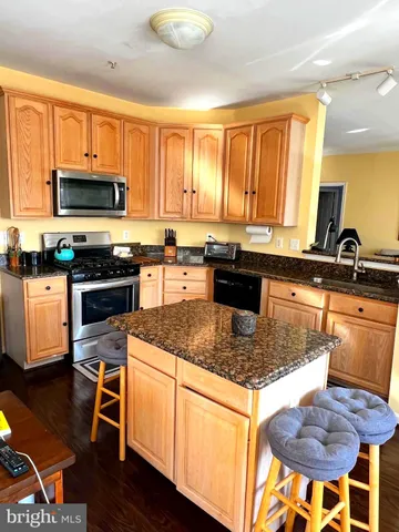 a kitchen with stainless steel appliances granite countertop a stove a sink a microwave and dining table