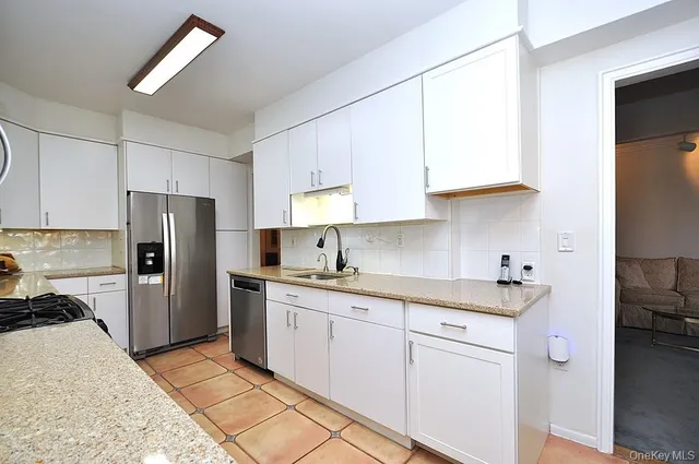 a kitchen with a sink a refrigerator and cabinets