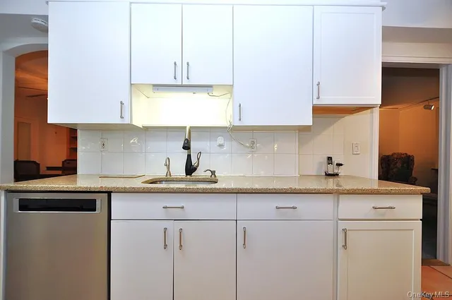 a kitchen with kitchen island granite countertop white cabinets and white appliances