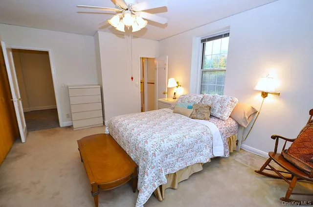 a spacious bedroom with a bed and a chandelier