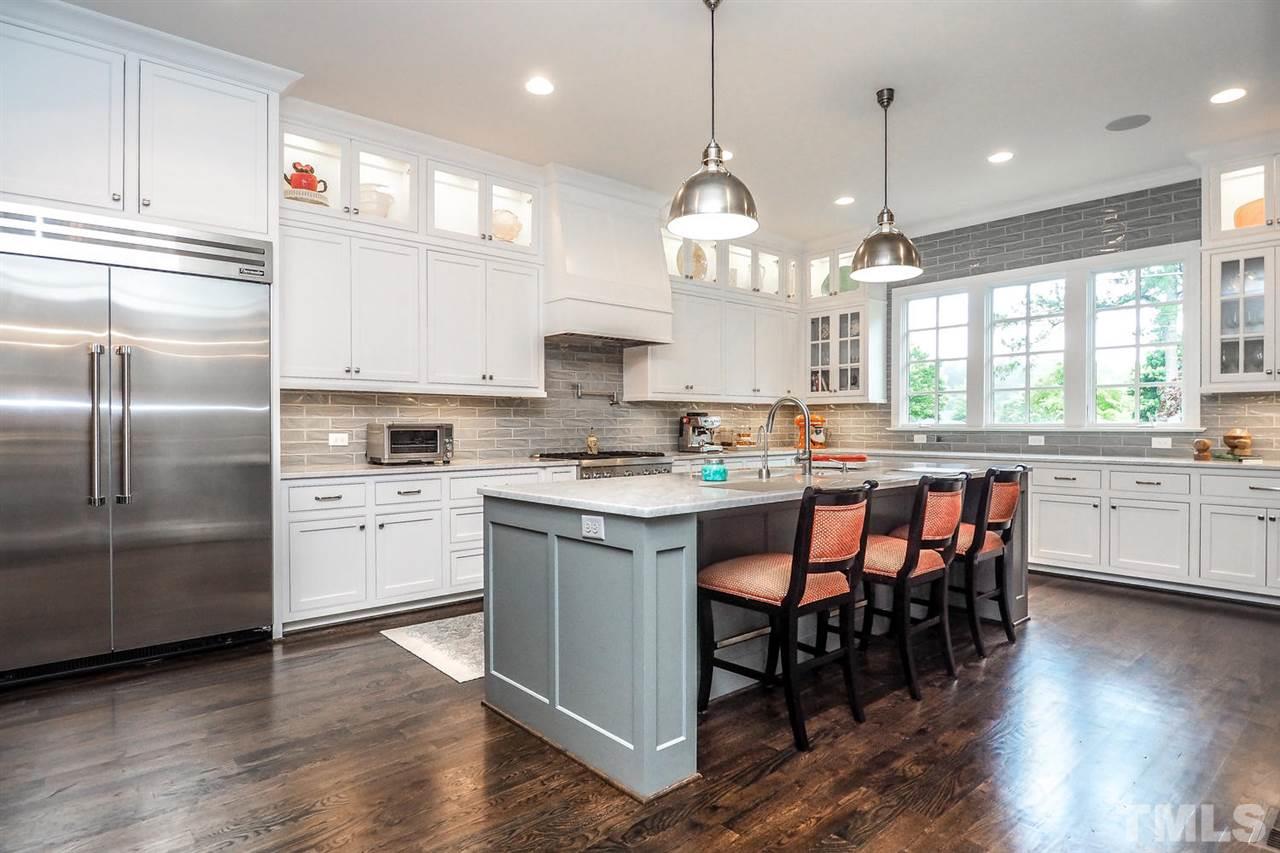 5005 Rampart Street Raleigh, NC 27609 - Photo 6 of 25 a kitchen with stainless steel appliances kitchen island granite countertop a stove a sink a center island and a window