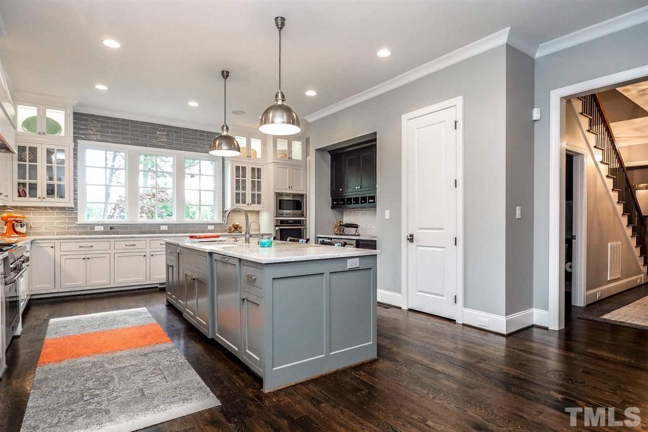 5005 Rampart Street Raleigh, NC 27609 - Photo 7 of 25 a large kitchen with stainless steel appliances granite countertop a stove a sink and a refrigerator