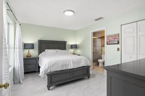 a spacious bedroom with a bed and a dresser