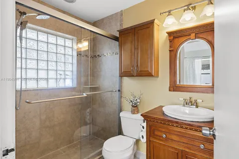 a bathroom with a granite countertop sink toilet a mirror and shower