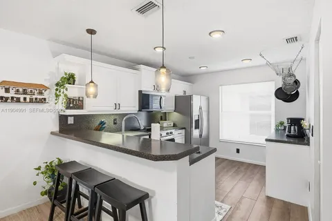 a kitchen with kitchen island a counter space a sink appliances and cabinets