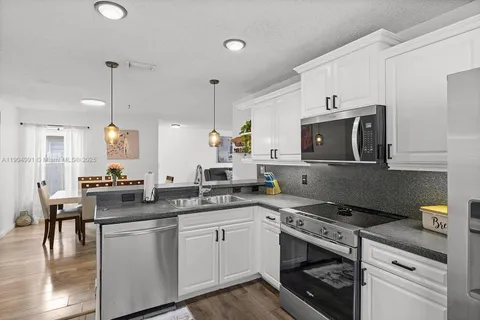 a kitchen with a sink stove and microwave