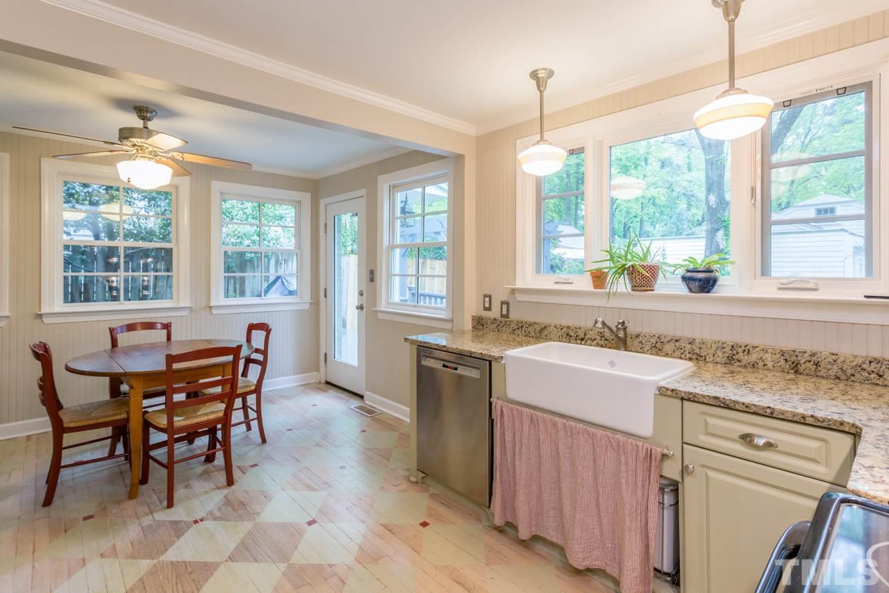 319 Furches Street Raleigh, NC 27607 - Photo 16 of 25 a kitchen with a stove a sink a dining table and chairs