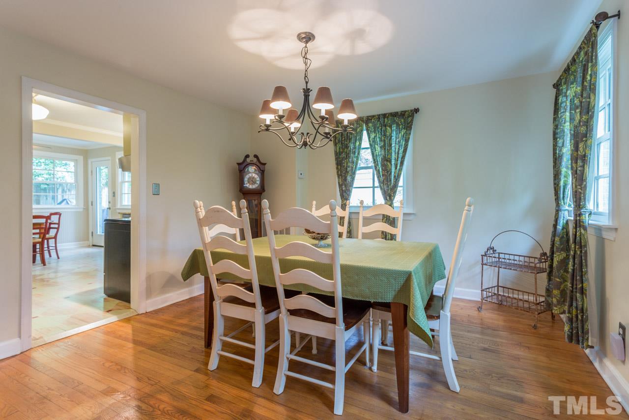 319 Furches Street Raleigh, NC 27607 - Photo 6 of 25 a dining room with wooden floor a chandelier a wooden table and chairs