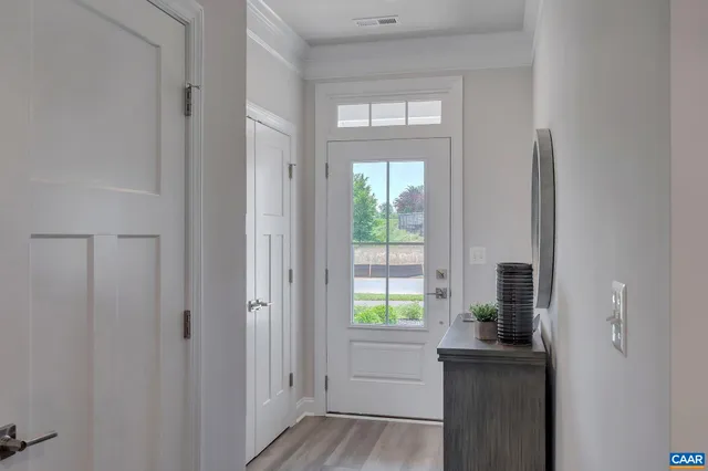 a kitchen with stainless steel appliances a refrigerator a stove a microwave oven a dining table and chairs with wooden floor