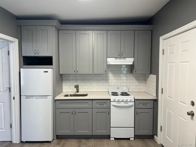 a kitchen with a refrigerator sink and cabinets