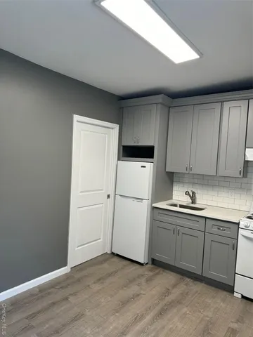 a kitchen with a sink a refrigerator and cabinets