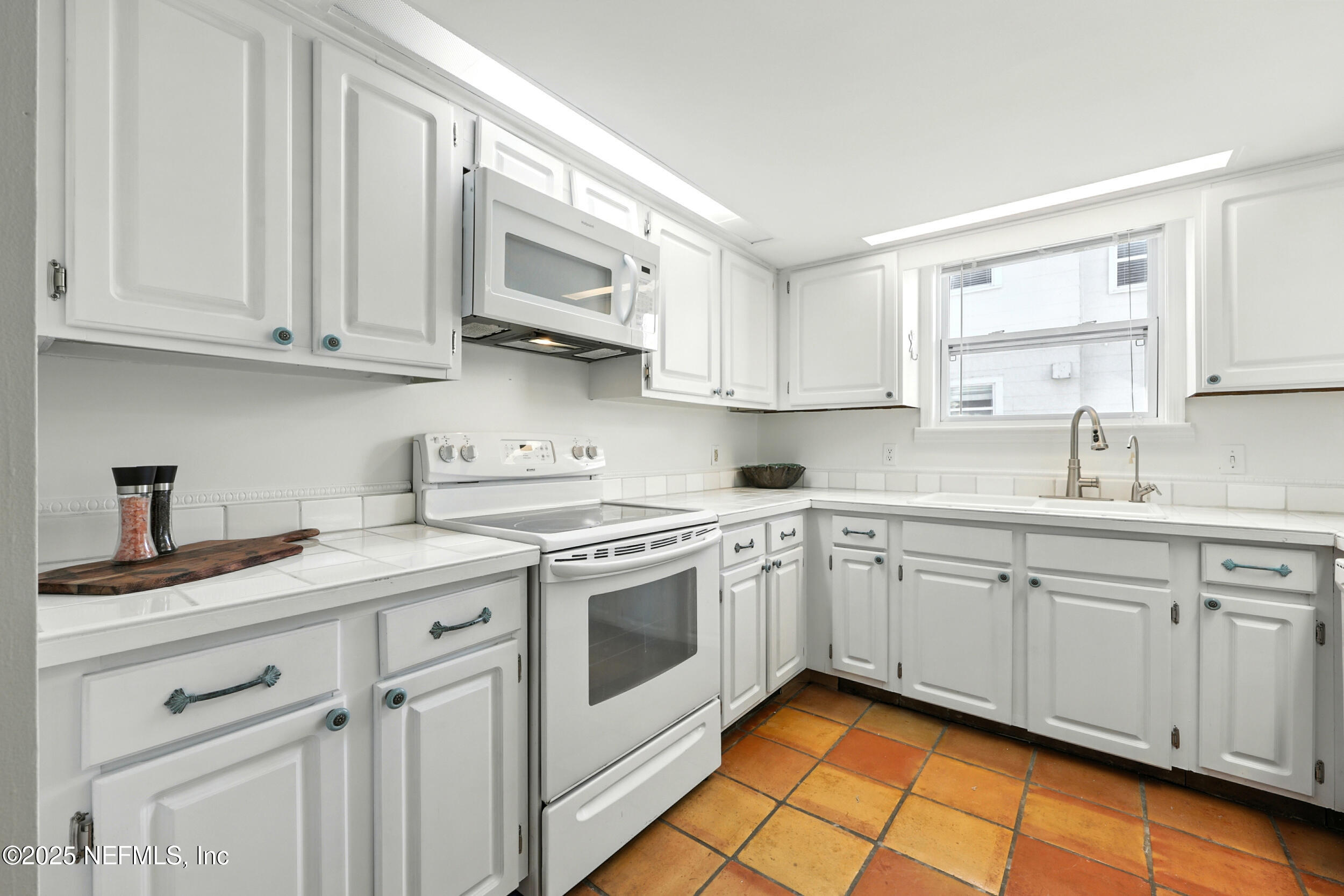 600 First Street Neptune Beach, FL 32266 - Photo 19 of 80 a kitchen with stainless steel appliances granite countertop white cabinets sink and stove