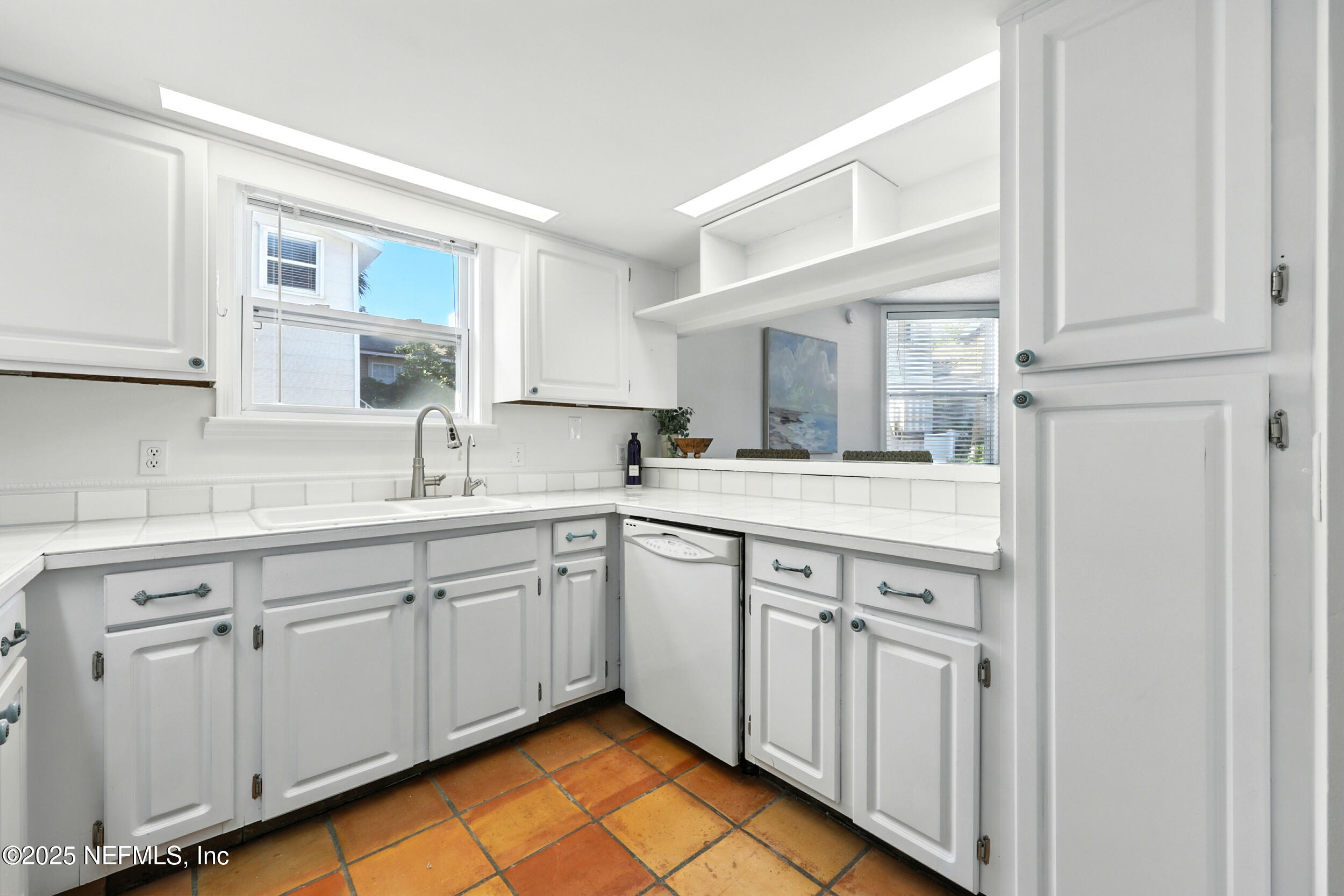 600 First Street Neptune Beach, FL 32266 - Photo 20 of 80 a kitchen with white cabinets sink and white appliances