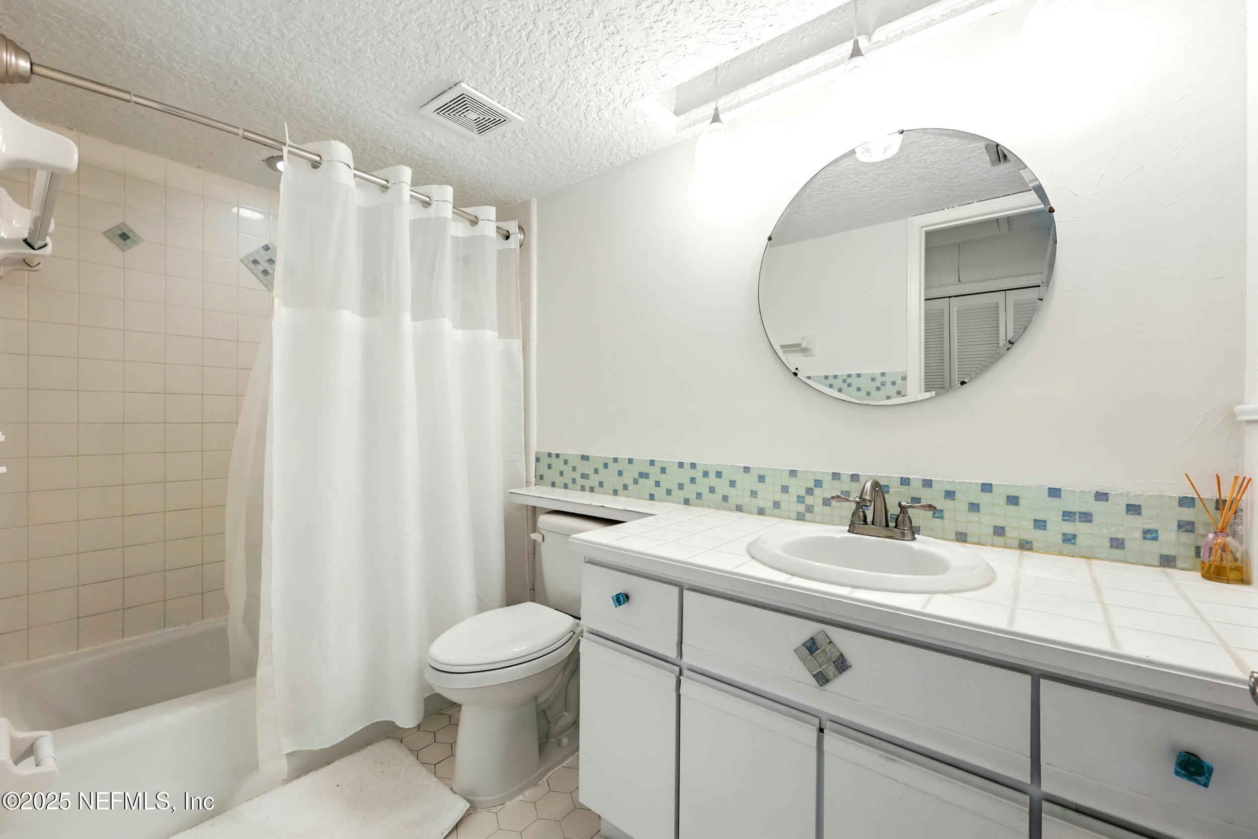 600 First Street Neptune Beach, FL 32266 - Photo 33 of 80 a bathroom with a sink a toilet and a mirror