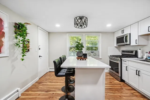 a view of a kitchen with kitchen island a counter top space a sink and appliances