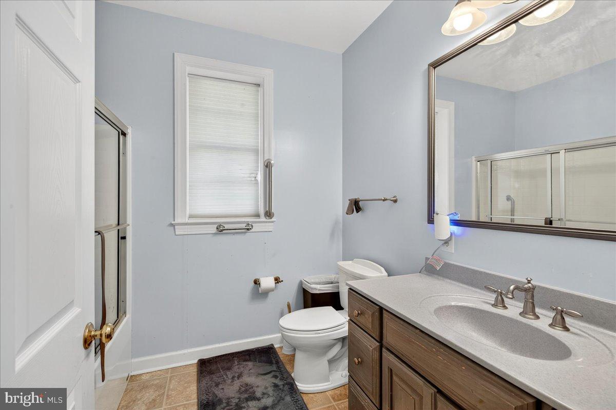 239 Mt Carmel Road Luray, VA 22835 - Photo 29 of 116 a bathroom with a granite countertop toilet a sink and a mirror
