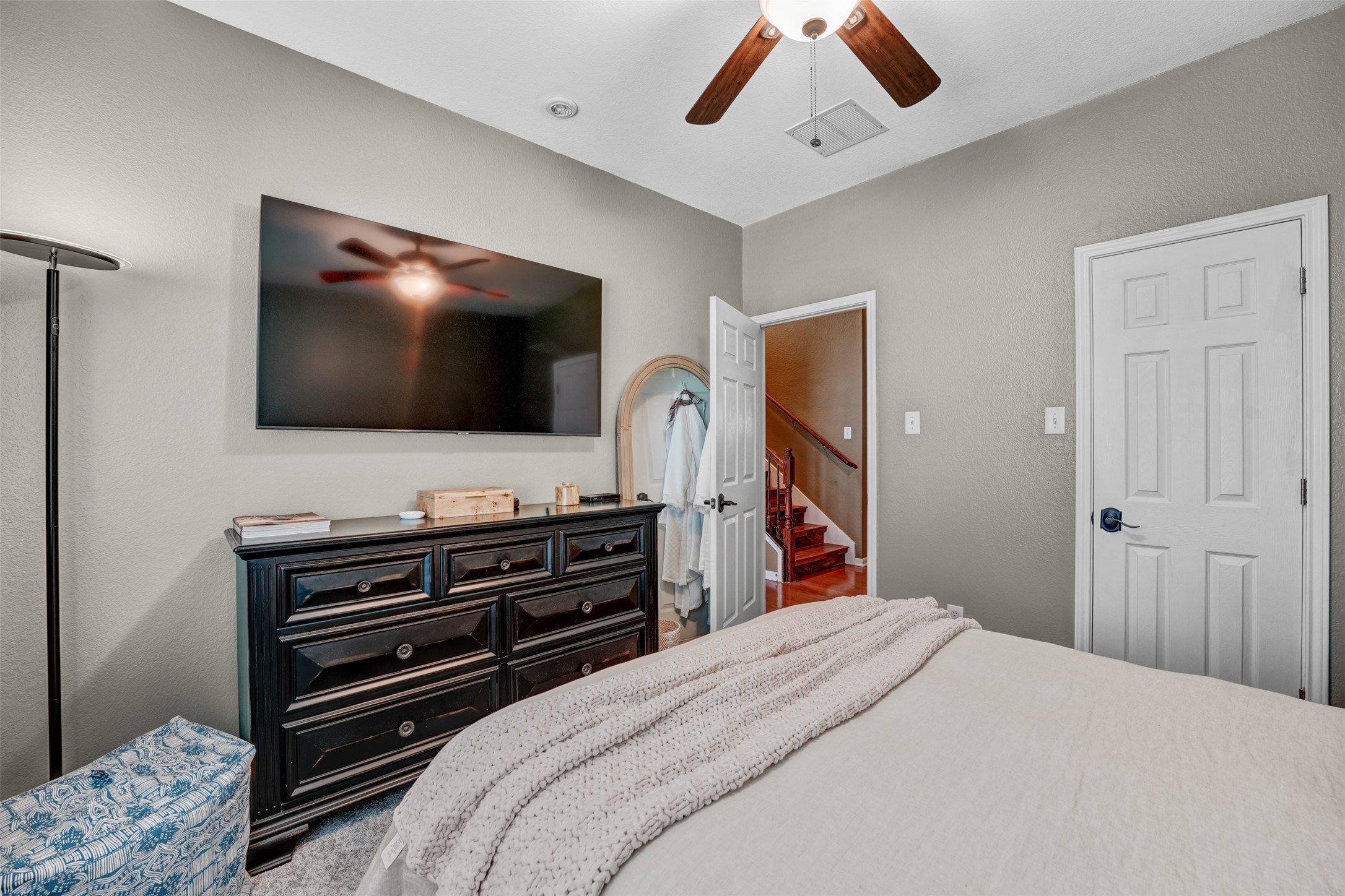 2521 Amen Corner Road Pflugerville, TX 78660 - Photo 24 of 40 Bedroom featuring a textured wall finish, a ceiling fan with integrated lighting, and white six-panel doors with dark hardware