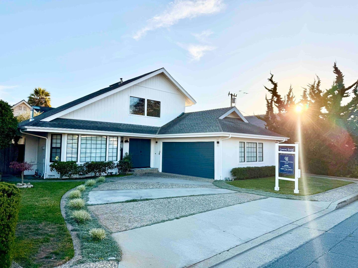 a front view of a house with a yard and potted plants