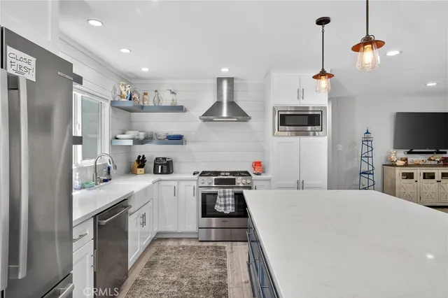 a kitchen with stainless steel appliances a stove a sink and a refrigerator
