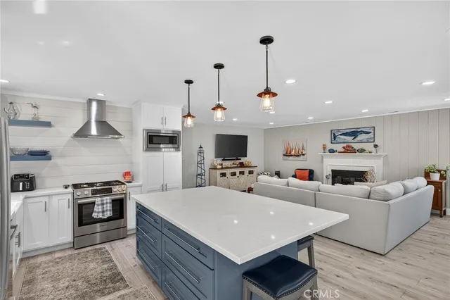 a large kitchen with stainless steel appliances granite countertop a stove a sink dishwasher and a microwave with wooden floor