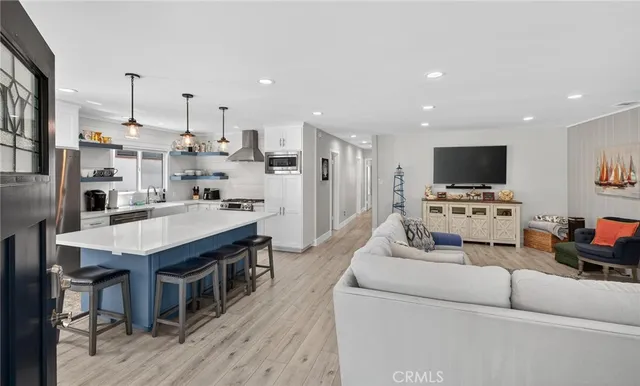 a large kitchen with stainless steel appliances kitchen island granite countertop a table chairs sink and cabinets