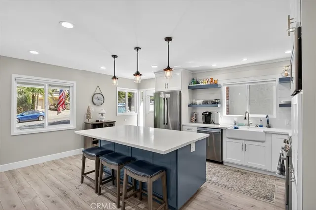 a large kitchen with kitchen island a sink a stove a dining table and chairs