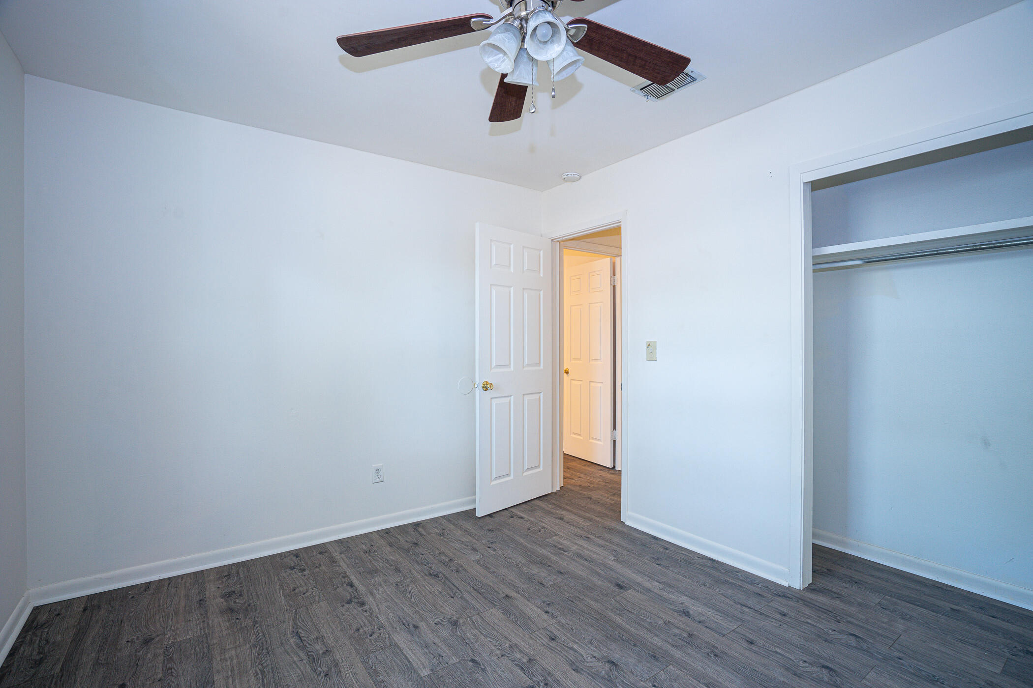 75 7th Street Shalimar, FL 32579 - Photo 14 of 19 an empty room with wooden floor ceiling fan and windows