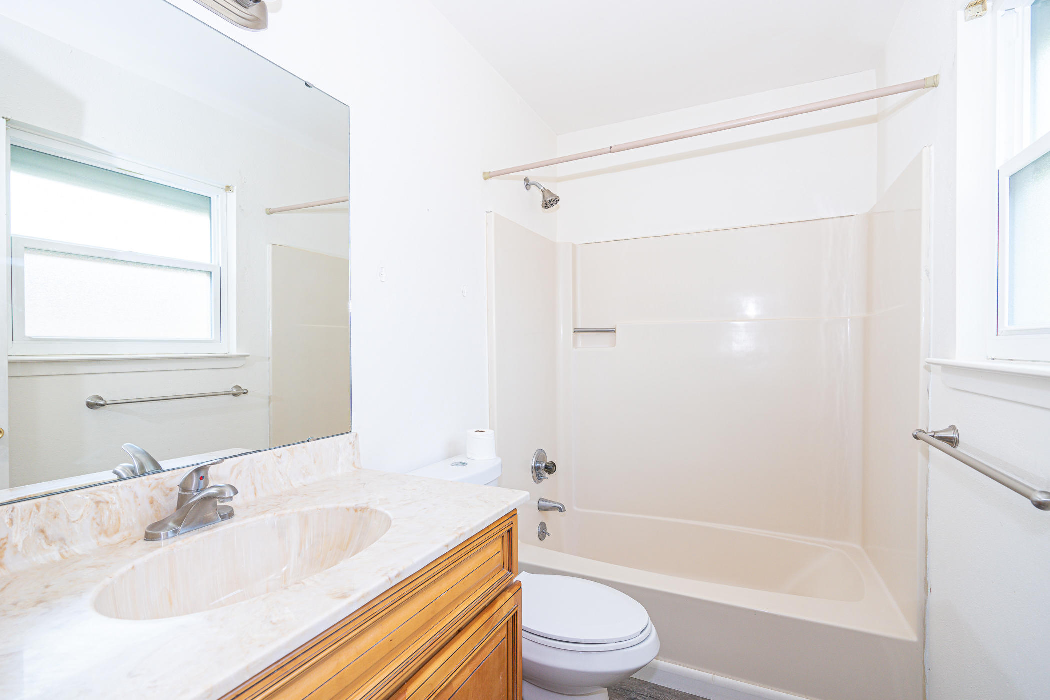 75 7th Street Shalimar, FL 32579 - Photo 16 of 19 a bathroom with a granite countertop bathtub shower sink vanity mirror and toilet