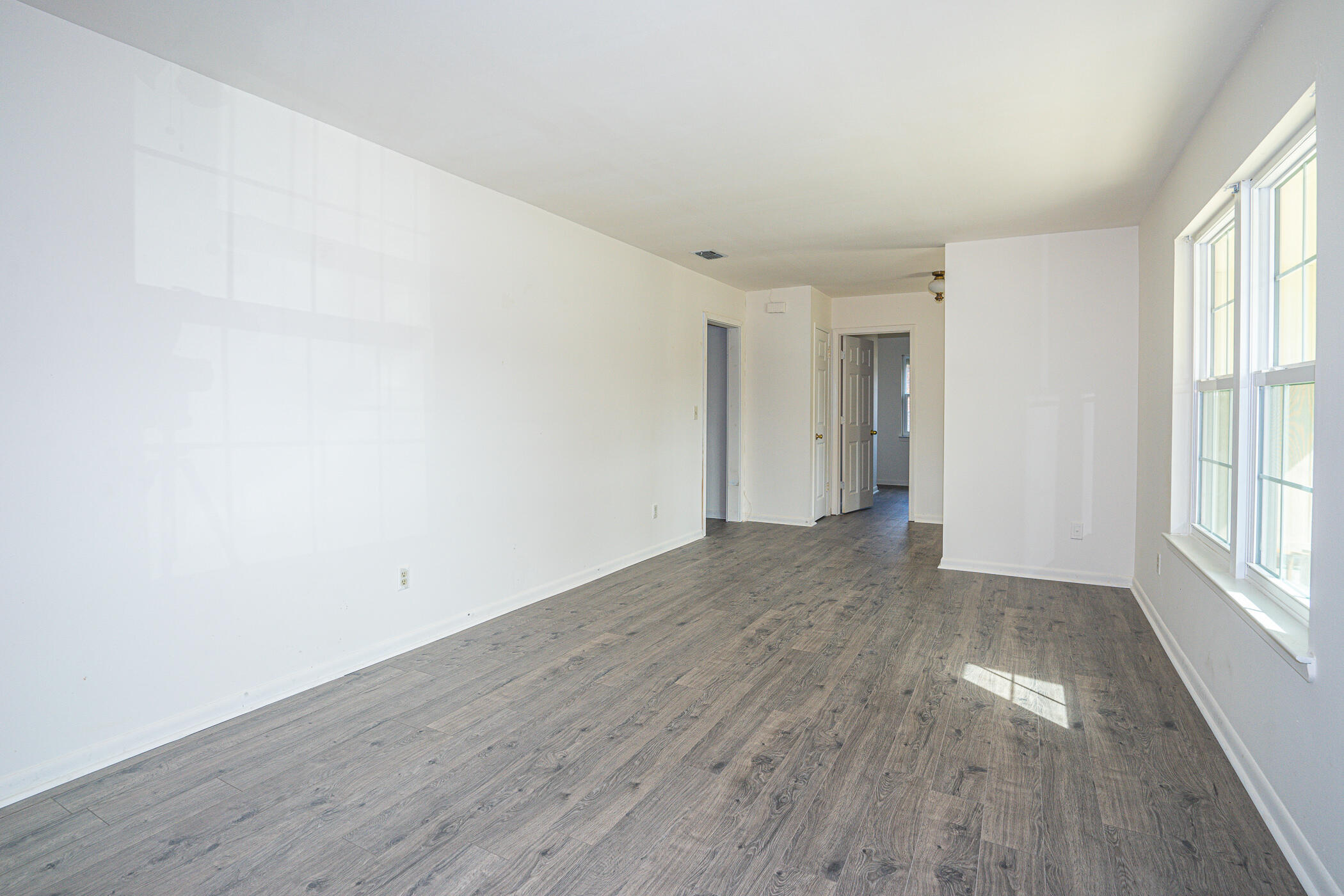 75 7th Street Shalimar, FL 32579 - Photo 4 of 19 a view of an empty room with wooden floor and windows