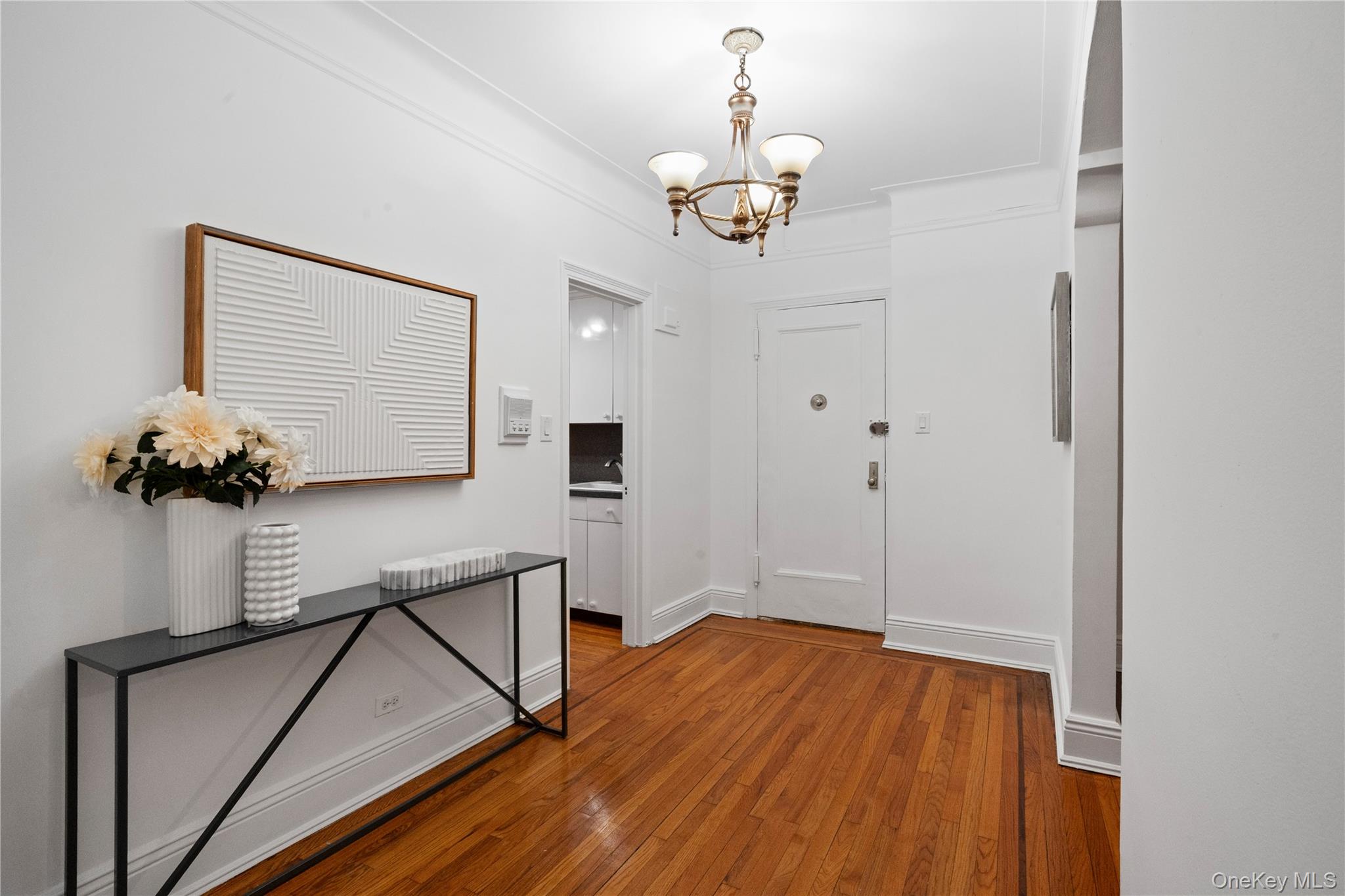 110-21 73rd Road, Unit 5H Queens, NY 11375 - Photo 4 of 14 Entryway with a chandelier and wood-type flooring