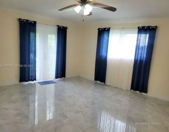 an empty room with closet and a chandelier fan