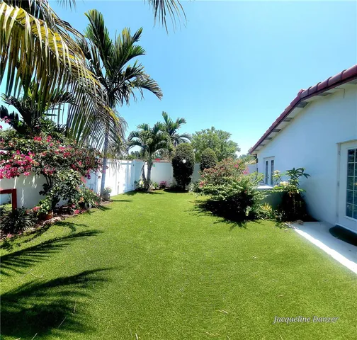 a view of a house with a yard and sitting area