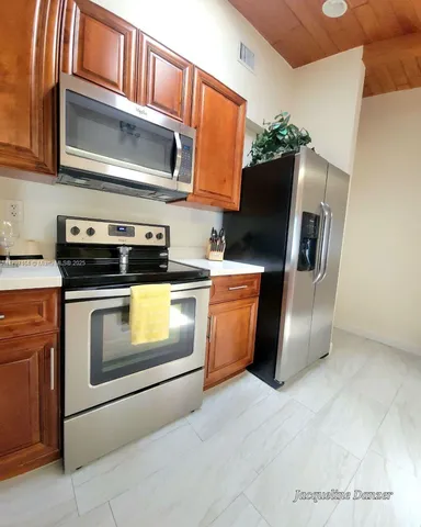 a kitchen with stainless steel appliances granite countertop a stove microwave and refrigerator