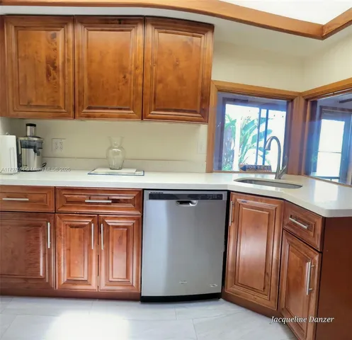 a kitchen with stainless steel appliances granite countertop cabinets and window