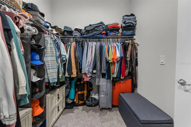 a view of walk in closet with clothes