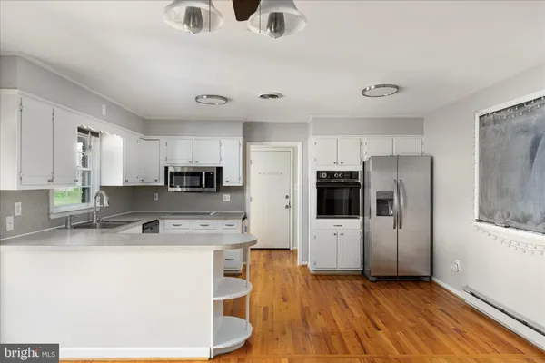 a kitchen with stainless steel appliances a refrigerator sink and microwave