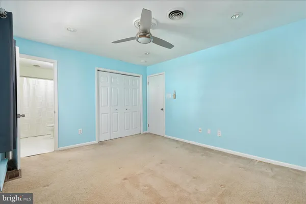 an empty room with a ceiling fan and a window