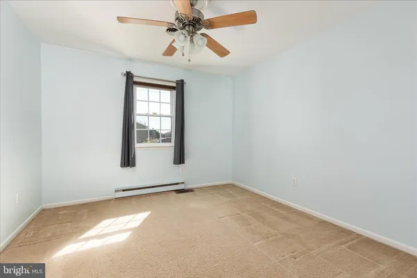 an empty room with a window and a fan