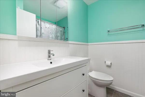 a bathroom with a sink a toilet and mirror