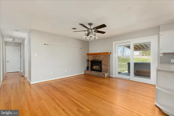 a view of an empty room with a fireplace and a window