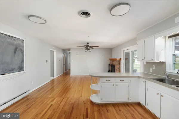 a kitchen with wooden floors and white walls