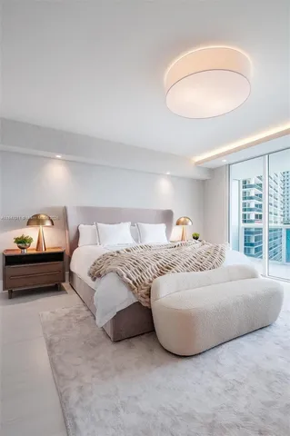 a bedroom with a bed and a large window