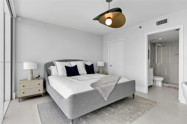 a bedroom with bed and a chandelier