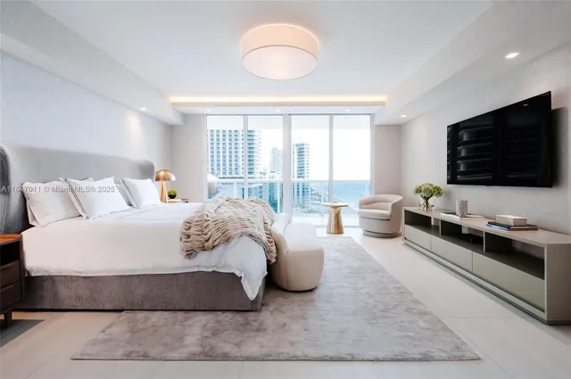 a spacious bedroom with a bed and a flat screen television